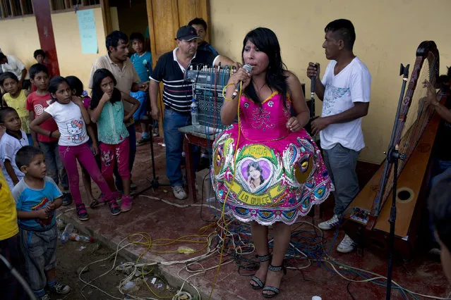 In this March 15, 2015 photo, huayno singer Nanda la Dulce performs during a multi-village soccer tournament, in La Mar, province of Ayacucho, Peru, located in the remote Apurimac, Ene and Mantaro river valley, where 60 percent of Peru's cocaine originates there. Huayno traditional Andean folk music. (Photo by Rodrigo Abd/AP Photo)
