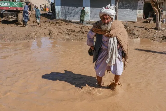 An Afghan elderly man walks through a flooded street following the flash floods after heavy rainfall in Guzara district of Herat province on March 13, 2024. At least 60 people have been killed by heavy rain and snow in Afghanistan over the past three weeks, the government's disaster ministry said on March 13. About 1,645 houses have been totally or partially ruined and nearly 178,000 livestock killed, ministry spokesman Janan Sayeq added. (Photo by Mohsen Karimi/AFP Photo)