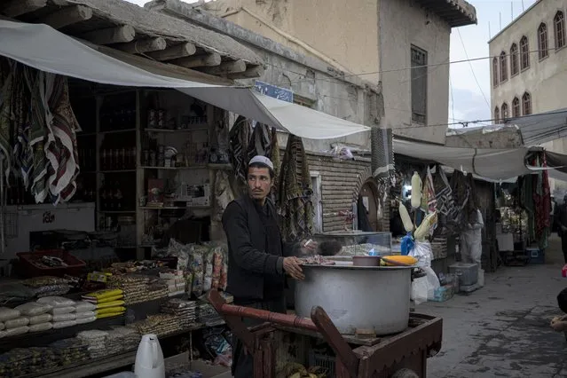 A street vendor sells corn in a predominantly Hazara neighborhood in Kabul, Afghanistan, Tuesday, November 9, 2021. (Photo by Bram Janssen/AP Photo)
