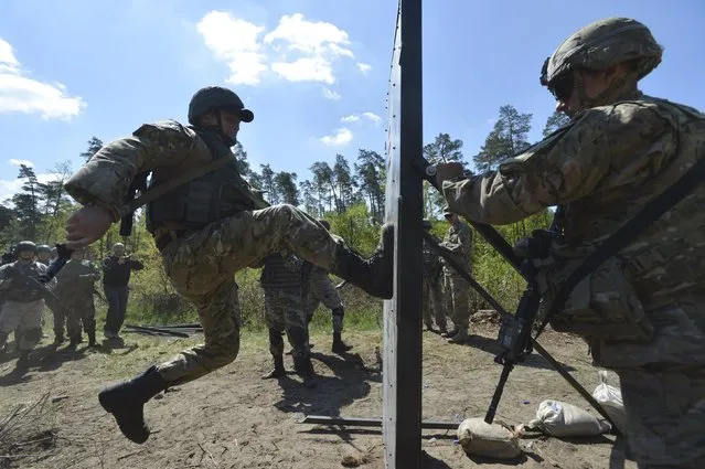 A serviceman of the U.S. Army's 173rd Airborne Brigade Combat Team (R) trains Ukrainian soldiers during a joint military exercise called “Fearless Guardian 2015” at the military training area in Yavoriv, outside Lviv, Ukraine, May 12, 2015. (Photo by Oleksandr Klymenko/Reuters)