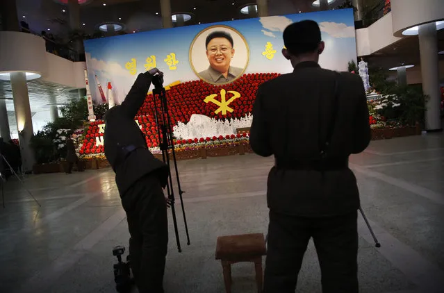 Military soldiers set up their cameras to photograph a flower display with the portrait of late North Korean leader Kim Jong Il as part of celebrations a day before the birthday anniversary, also known as the “Day of the Shining Star”, of late North Korean leader Kim Jong Il on Monday, February 15, 2016, in Pyongyang, North Korea. (Photo by Wong Maye-E/AP Photo)
