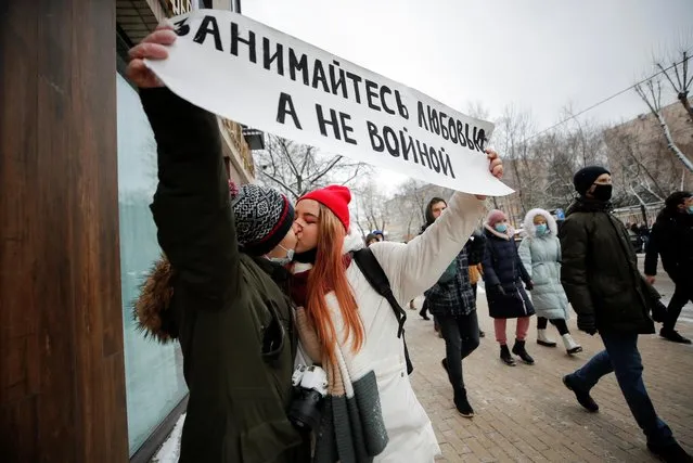 People hold up a banner reading “Make love not war” while they kiss during a rally in support of jailed Russian opposition leader Alexei Navalny in Moscow, Russia on January 31, 2021. (Photo by Maxim Shemetov/Reuters)