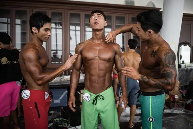 Male bodybuilders prepare to compete in the 'Mr Athletic' category of the NABA/WFF Asia-Seoul Open Championship in Seoul on April 17, 2016. (Photo by Ed Jones/AFP Photo)