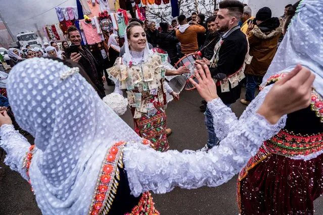 Muslim bride Nefie Eminkova, (L) and the groom Shaban Kiselov, (R) dance on a street, during their wedding day on January 9, 2022 in Ribnovo, Bulgaria. Bulgarian Pomaks from Ribnovo have their unique weddings only in the winter. The weddings continue two or three days and the bride must marry with her eyes closed and her face painted white with shining sequins. An estimated one million Muslims live in Bulgaria, approximately 10 per cent of the country's population.  (Photo by Hristo Rusev/Getty Images)