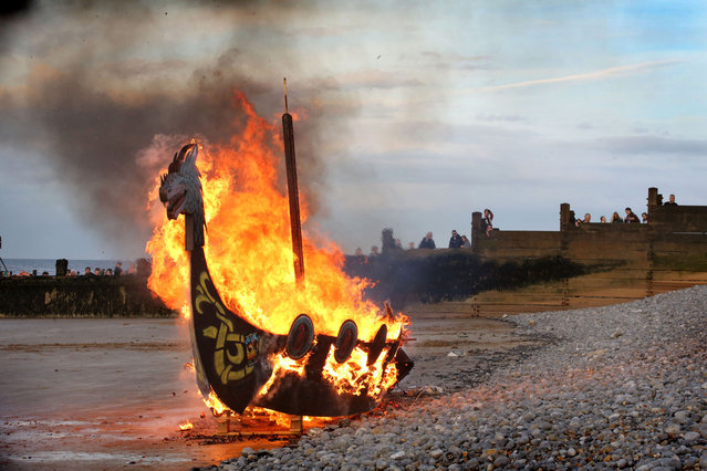 The model of the Viking longship is consumed by fire on the beach on April 13, 2024 in Sheringham, United Kingdom. The festival is run by Waffa Viking and Saxon Re-enactment Society and demonstrates traditional skills, battle reenactment, a torchlight procession and a boat burning finale. (Photo by MartinPope/Getty Images)