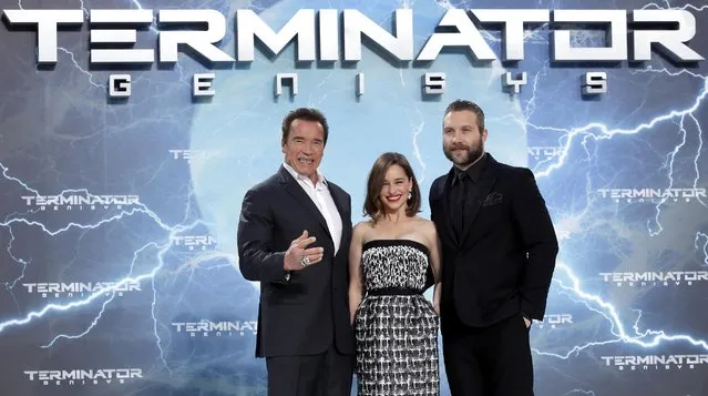 Actors Arnold Schwarzenegger, left, Emilia Clarke and Jai Courtney, right, pose for the photographers as they arrive for the Europe premiere of the movie 'Terminator: Genisys' in Berlin, Germany, Sunday, June 21, 2015. (AP Photo/Michael Sohn)