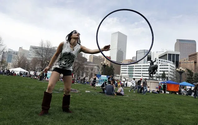 Vanessa Vitali plays with a hoop at the annual 4/20 marijuana festival near downtown Denver at Civic Center Park, Saturday, April 19, 2014. The two-day festival, which is expected to draw tens of thousands of people, features music, vendors and speakers in Civic Center Park in front of the state capitol building. (Photo by Brennan Linsley/AP Photo)