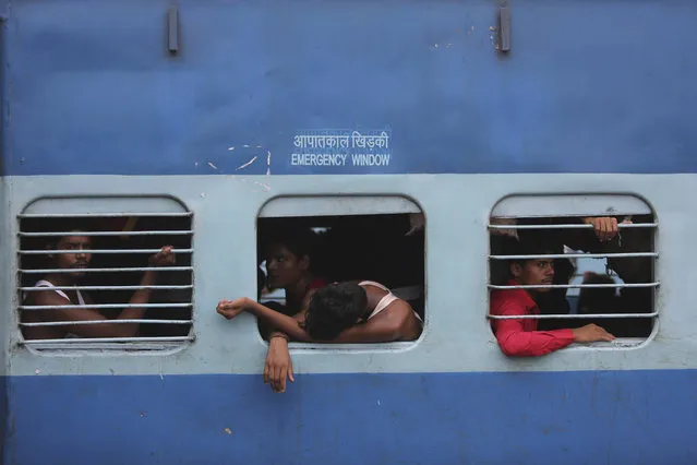 Indian migrant laborers sit inside a train as they prepare to leave the region, at a railway station in Jammu, India, Wednesday, August 7, 2019. Indian lawmakers passed a bill Tuesday that strips statehood from the Indian-administered portion of Muslim-majority Kashmir, which remains under an indefinite security lockdown, actions that archrival Pakistan warned could lead to war. (Photo by Channi Anand/AP Photo)