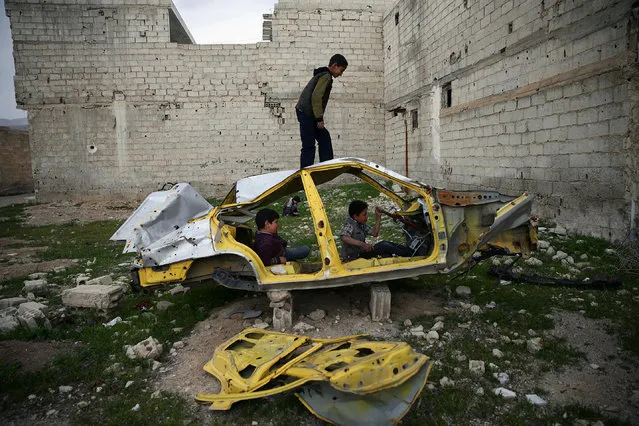 Boys play on a wrecked car in the rebel held besieged Douma neighbourhood of Damascus, Syria April 1, 2017. (Photo by Bassam Khabieh/Reuters)