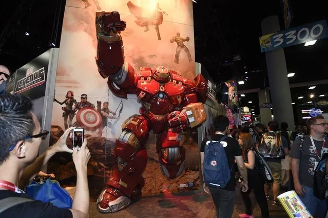 Fans take photos of the Marvel Legend booth on Preview Night at Comic-Con International held at the San Diego Convention Center Wednesday, July 8, 2015, in San Diego. (Photo by Denis Poroy/Invision/AP Photo)