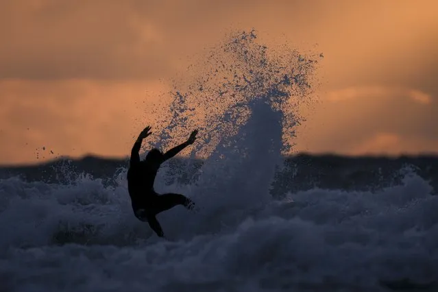 A professional surfer maneuvers on a wave in the Mediterranean Sea after competing in the first round of the Qualifying Series of the world Surf League event in Netanya, Israel, Tuesday, March 15, 2022. (Photo by Ariel Schalit/AP Photo)