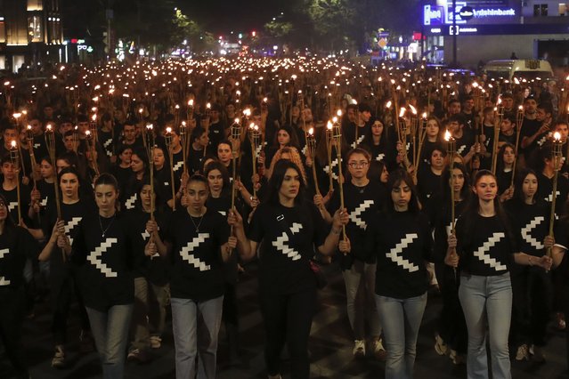 A torchlight procession marches during a demonstration in Yerevan, Armenia, Sunday, April 23, 2023, to commemorate the estimated 1.5 million Armenians killed in Ottoman Turkey more than a century ago. (Photo by Hayk Baghdasaryan/Photolure via AP Photo)