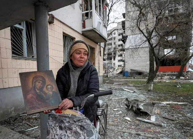 Local resident Olga holds an icon, which she takes away from her destroyed apartment in Borodyanka, amid Russia's invasion of Ukraine, in Kyiv region, Ukraine, April 5, 2022. (Photo by Gleb Garanich/Reuters)