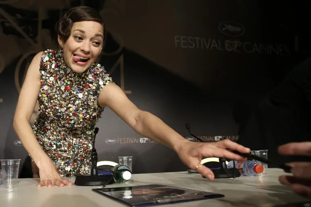 Actress Marion Cotillard signs autographs following a press conference for Two Days, One Night (Deux jours, une nuit) at the 67th international film festival, Cannes, southern France, Tuesday, May 20, 2014. (Photo by Thibault Camus/AP Photo)