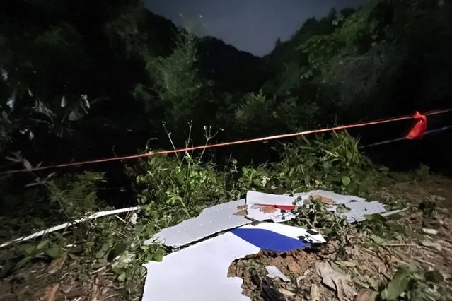 In this photo released by China's Xinhua News Agency, debris is seen at the site of a plane crash in Tengxian County in southern China's Guangxi Zhuang Autonomous Region, Tuesday, March 22, 2022. A China Eastern Boeing 737-800 with more than 100 people on board crashed in a remote mountainous area of southern China on Monday, officials said, setting off a forest fire visible from space in the country's worst air disaster in nearly a decade. (Photo by Zhou Hua/Xinhua via AP Photo)