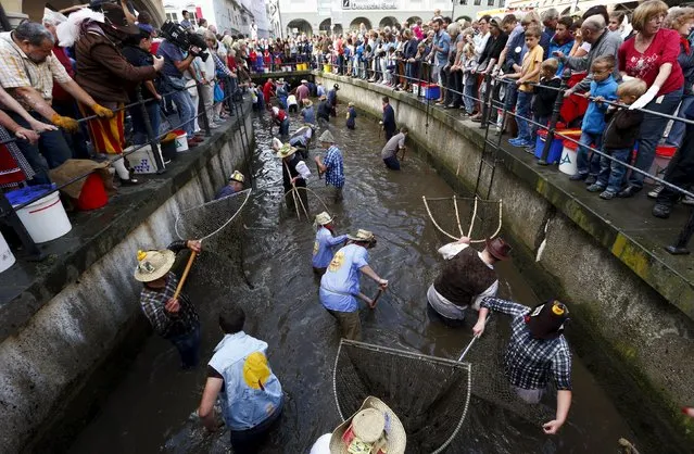 Fishermen try to catch trouts in a small river as they celebrate Fischertag (Fisherman's Day) in downtown Memmingen, southern Germany, July 25, 2015. (Photo by Michaela Rehle/Reuters)
