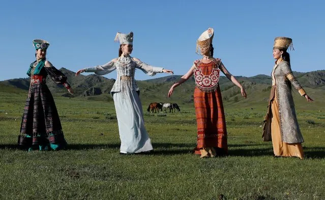 Models of the “Altyr” fashion theatre, dressed in Khakas national costumes, perform during a photo session, as a part of the rehearsal for the Tun-Pairam traditional holiday (The Holiday of the First Milk) celebration at a museum preserve outside Kazanovka village near Abakan in the Republic of Khakassia, Russia, May 28, 2016. The museum preserve is located in a picturesque forest-steppe valley near the Abakan ridge of the Kuznetsk Alatau mountain range and displays numerous objects of the cultural and historical heritage of various epochs accumulated by the people living on this territory, according to representatives. (Photo by Ilya Naymushin/Reuters)