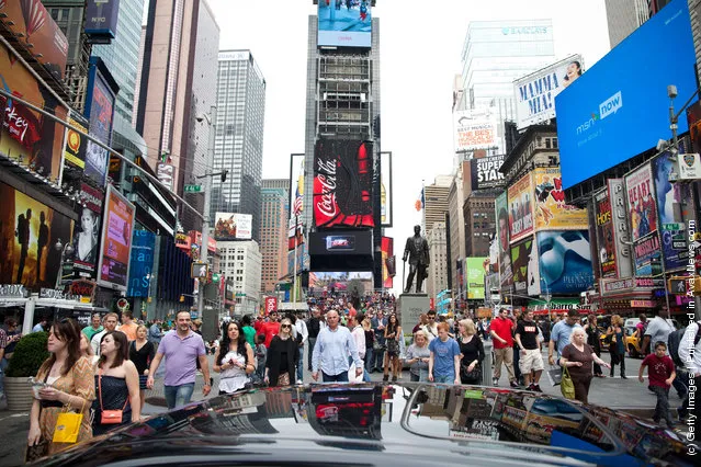 People walk through Times Square on March 23, 2012 in New York City