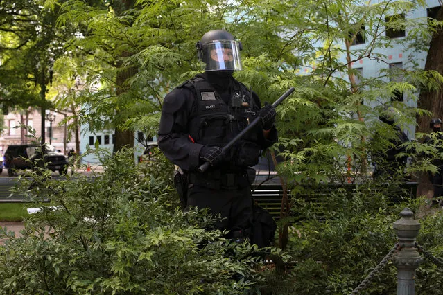 A law enforcement officer prevents anti-fascist protesters from entering a park after removing them during competing demonstrations in Portland, Oregon, U.S. June 4, 2017. (Photo by David Ryder/Reuters)