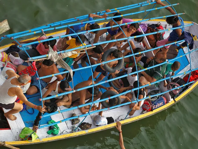 People commute in a boat as they head to learn swimming in the waters of the Yamuna river in Allahabad, India June 16, 2017. (Photo by Jitendra Prakash/Reuters)