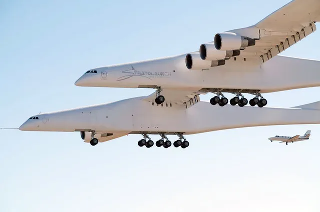 This handout photograph obtained courtesy of Stratolaunch shows the Stratolaunch plane flying over the California desert, April 13, 2019, the first test flight of the US company's gigantic aircraft whose wingspan is almost half that of an Airbus A380. The world's largest airplane – a Stratolaunch behemoth with two fuselages and six Boeing 747 engines – made its first test flight on Saturday, April 13, 2019 in California. The strange aircraft, built by the legendary aeronautical engineering company Scaled Composites in the Mojave Desert, has two fuselages and is powered by six Boeing 747 engines. It must theoretically be used to carry and drop at altitude a small rocket that will then light its engine, and will propel to space to place satellites in orbit. This is a more flexible method of accessing the space than vertical rocket takeoffs, as a large take-off runway would suffice. (Photo by Stratolaunch Systems Corp/AFP Photo/Handout)