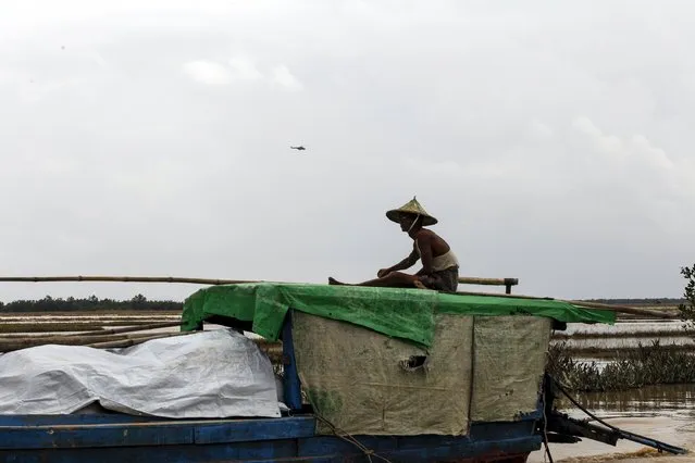 A man steers his boat as a military helicopter flies past, at a river in Mrauk-U township, Rakhine state August 4, 2015. (Photo by Soe Zeya Tun/Reuters)