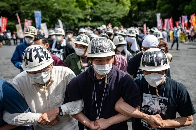 A group of activists chant slogans as they protest against US President Joe Biden's visit to Japan, in Tokyo on May 22, 2022. (Photo by Philip Fong/AFP Photo)