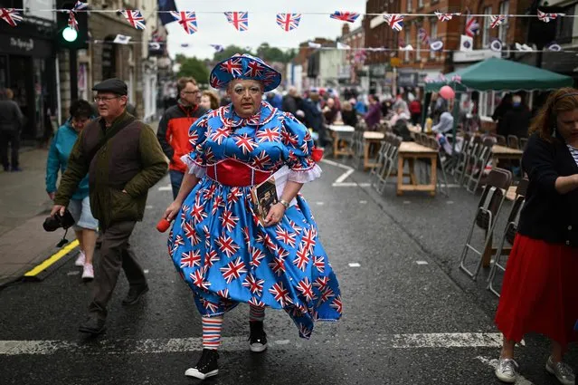 A reveller wearing a dress bearing British national flags arrives to attend a street party in Ashby-de-la-Zouch in central England on June 5, 2022 as part of Queen Elizabeth II's platinum jubilee celebrations. Millions of people are expected to attend “Big Jubilee Lunch” picnics, as a long weekend of festivities to honour Queen Elizabeth II's historic Platinum Jubilee concludes. (Photo by Oli Scarff/AFP Photo)
