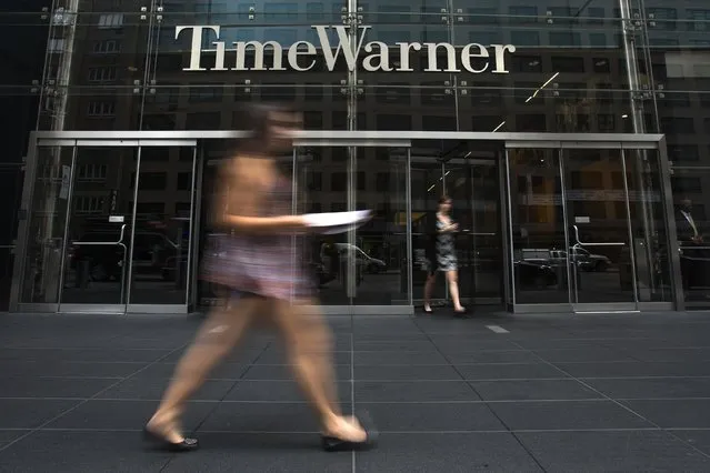 A woman walks past the Time Warner Center near Columbus Circle in Manhattan, New York July 16, 2014. Rupert Murdoch's 21st Century Fox Inc said on Wednesday it had offered to buy Time Warner Inc, a move that would unite two of the world's most powerful media conglomerates, but Time Warner rebuffed its offer. (Photo by Adrees Latif/Reuters)