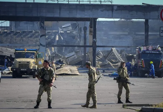 Ukrainian soldiers stand in front of a shopping center burned after a rocket attack in Kremenchuk, Ukraine, Tuesday, June 28, 2022. (Photo by Efrem Lukatsky/AP Photo)
