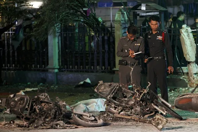 Experts investigate the remains of destroyed motorcycles at the Erawan shrine, the site of the blast in central Bangkok August 17, 2015. (Photo by Kerek Wongsa/Reuters)