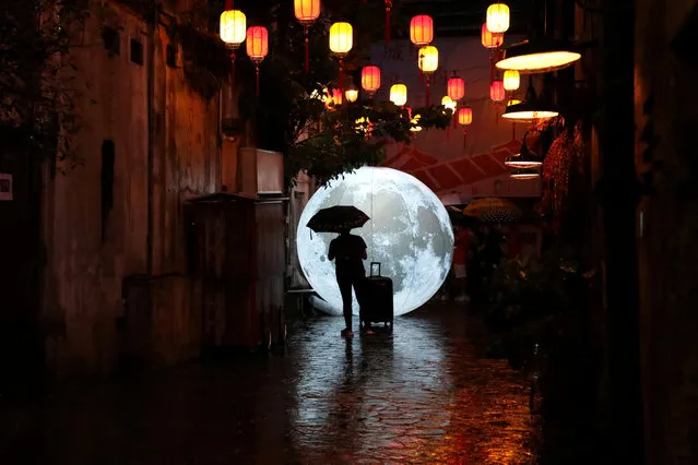 A tourist stands in front of a moon installation ahead of celebrations for the Mid-Autumn Festival at China Town in Kuala Lumpur, Malaysia, August 24, 2019. (Photo by Lim Huey Teng/Reuters)