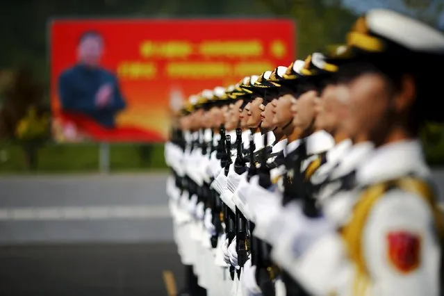 A picture of Chinese President Xi Jinping is seen behind soldiers of China's People's Liberation Army marching during a training session for a military parade to mark the 70th anniversary of the end of the World War Two, at a military base in Beijing, China, August 22, 2015. (Photo by Damir Sagolj/Reuters)