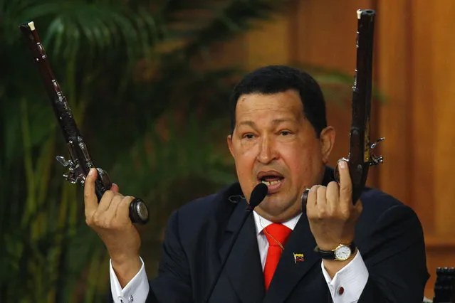 Venezuelan President Hugo Chavez shows the pistols of independence hero Simon Bolivar during a ceremony to mark the his birthday in Caracas July 24, 2012. Chavez unveiled a 3D image of South America's 19th century independence hero Bolivar on Tuesday, based on bones he had exhumed two years ago to test a theory that Bolivar was murdered. (Photo by Carlos Garcia Rawlins/Reuters)