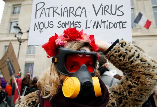 A woman in a gas mask attends a protest demanding equality on International Women's Day in Paris, France, March 8, 2020. The placard reads “Patriarchy virus. We are the antidote”. (Photo by Pascal Rossignol/Reuters)