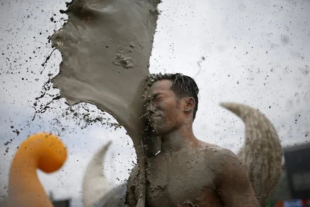 A tourist plays with mud during the Boryeong Mud Festival at Daecheon beach in Boryeong, South Korea, July 16, 2016. (Photo by Kim Hong-Ji/Reuters)