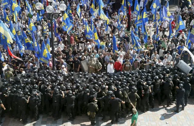Demonstrators, who are against a constitutional amendment on decentralization, clash with police outside the parliament building in Kiev, Ukraine, August 31, 2015. Ukraine's parliament voted on Monday for constitutional changes to give separatist-minded eastern regions a special status – but divisions in the pro-Western camp and violent street protests suggested the changes would face a rougher ride to become law. (Photo by Valentyn Ogirenko/Reuters)