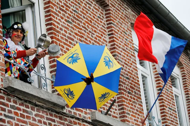 A man wearing a local carnival costume looks on from a window during the parade of “Carnaval de Cassel” as a lockdown is imposed to slow the spread of the coronavirus disease (COVID-19) in Cassel, France on April 13, 2020. (Photo by Pascal Rossignol/Reuters)
