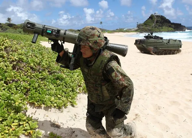 A soldier with the Japan Maritime Self-Defense Force (JMSDF) runs up the beach to set up a perimeter defense during a simulated beach assault at Marine Corps Base Hawaii with the 3rd Marine Expeditionary Unit during the multi-national military exercise RIMPAC in Kaneohe, Hawaii, July 30, 2016. (Photo by Hugh Gentry/Reuters)