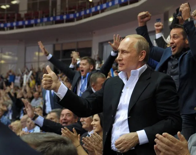 Russian President Vladimir Putin, foreground right, gestures, as he attends the Judo World Cup in the city of Chelyabinsk in Siberia, Russia, on Sunday, August 31, 2014. Putin is calling on Ukraine to immediately start talks on a political solution to the crisis in eastern Ukraine, including discussing statehood. (Photo by Alexei Druzhinin/AP Photo/RIA Novosti/Presidential Press Service)