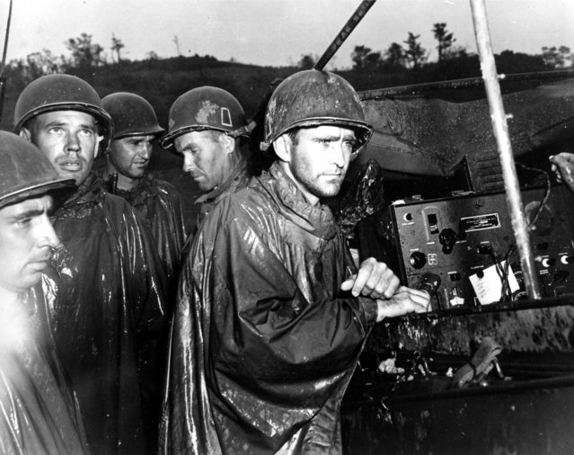 Fighting men of the U.S. Army's 77th Infantry Division on Ryukyu Island in Japan hear the news of Germany's surrender on May 8 a few yards behind the front lines during World War II. (Photo by AP Photo/U.S. Army Signal Corps)