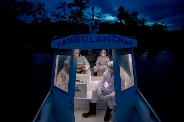 Health workers from the city of Melgaco ride a boat ambulance on their way back after visiting eight families that live without electricity in a small riverside community at the Quara river, amid concern over the spread of the COVID-19 coronavirus, in the southwest of Marajo Island, state of Para, Brazil, on June 9, 2020. (Photo by Tarso Sarraf/AFP Photo)