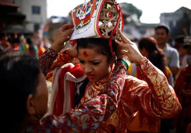 A girl is dressed up to participate in a parade to mark the Gaijatra festival, also known as “cow festival”, in Kathmandu, Nepal, August 19, 2016. Hindus in Kathmandu celebrate the festival to ask for salvation and peace for their departed loved ones. Cows are regarded as holy animals in Nepal which help departed souls to reach heaven. (Photo by Navesh Chitrakar/Reuters)
