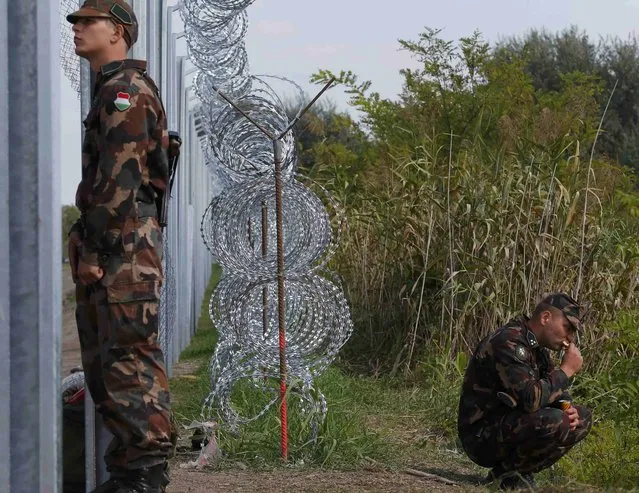 Hungarian soldiers stand guard along a fence on the border crossing point from Serbia into the country, near Roszke, Hungary September 13, 2015. (Photo by Laszlo Balogh/Reuters)