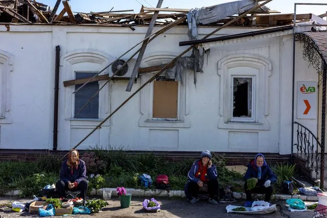 Locals sell vegetables in front of a damaged market in Balakliia, recently liberated by Ukrainian Armed Forces, amid Russia's invasion of Ukraine, in Kharkiv region, Ukraine on September 21, 2022. (Photo by Umit Bektas/Reuters)