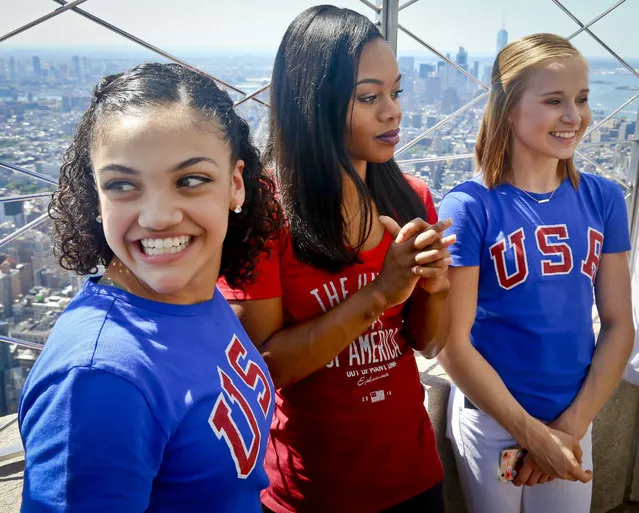U.S. Gymnasts back from the Rio Olympics, from left, Laurie Hernandez, Gabby Douglas and Madison Kocian smile during a visit to the Empire State Building in New York, Tuesday August 23, 2016. (Photo by Bebeto Matthews/AP Photo)