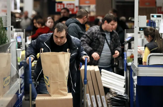Moscow residents buy goods in the IKEA store in Moscow, Russia, 19 December 2014. In anticipation of rising prices, many shops in Russia observed excessive demand in their commodities. IKEA temporarily suspended sales of kitchen appliances and furniture in Russia. The Russian currency crashed to historic lows against the dollar and the euro on 16 December, despite a massive interest rate hike to 17 per cent. (Photo by Yuri Kochetkov/EPA)