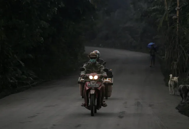 Motorists drive on a road covered in volcanic ash from Mount Agung's eruption in Karangasem, Bali, Indonesia on November 26, 2017. (Photo by Johannes P. Christo/Reuters)