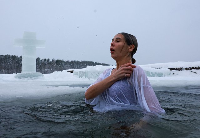 A woman takes a dip in icy water during celebrations of the Orthodox Christian feast of Epiphany in the town of Sertolovo in the Leningrad Region, Russia on January 19, 2024. (Photo by Anton Vaganov/Reuters)