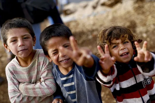 Kurdish refugee children from the Syrian town of Kobani show victory signs in a camp in the southeastern town of Suruc on the Turkish-Syrian border, October 19, 2014. (Photo by Kai Pfaffenbach/Reuters)